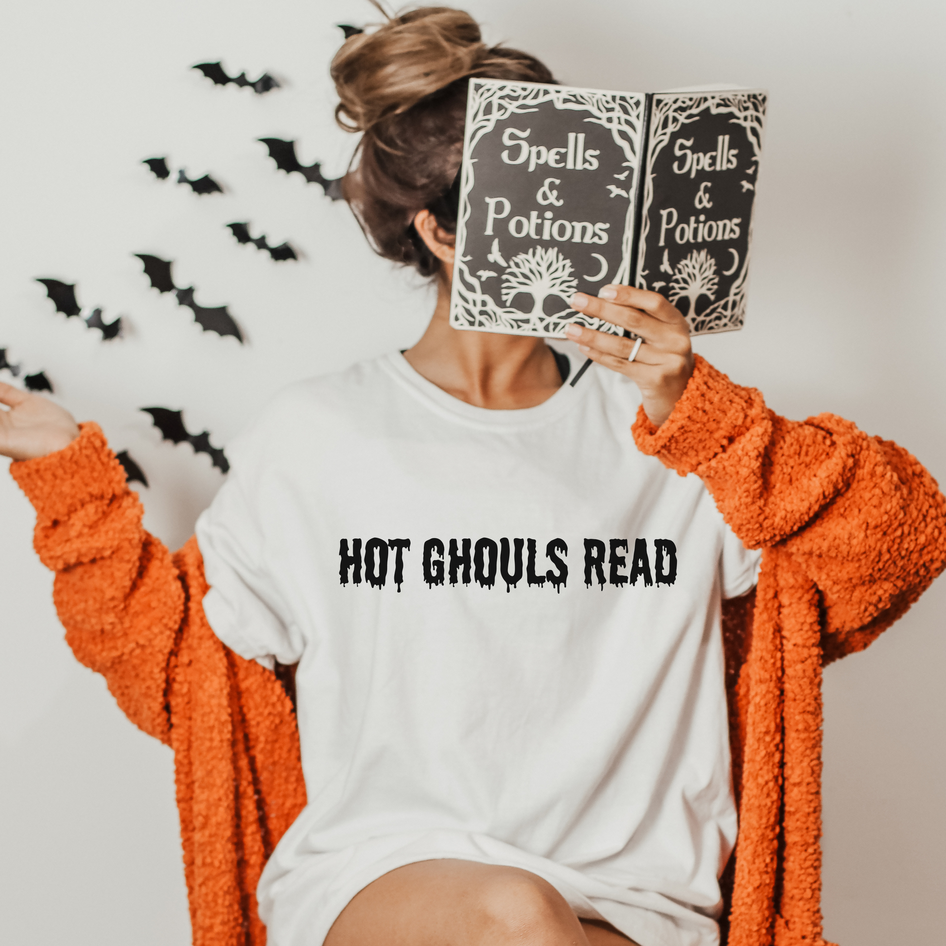 white crewneck. Unleash your inner bookworm as you wrap yourself in the pages of your favorite reads, all while embracing the spine-tingling atmosphere of Halloween. This isn't just any crewneck shirt; it's a statement of your love for literature, entwined with the captivating mystery of the season